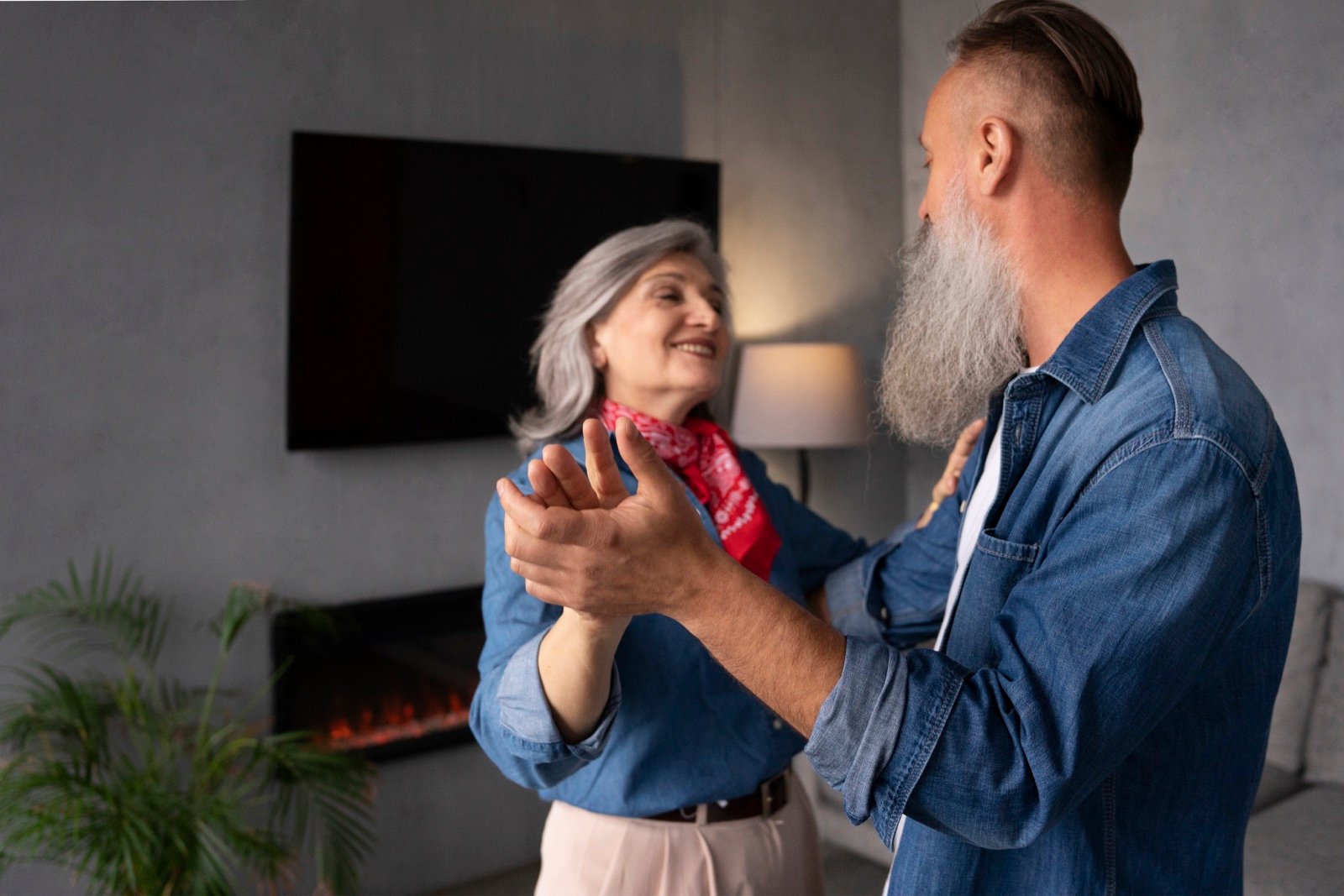 Seniorpar danser hjemme og viser nærvær i et modent forhold