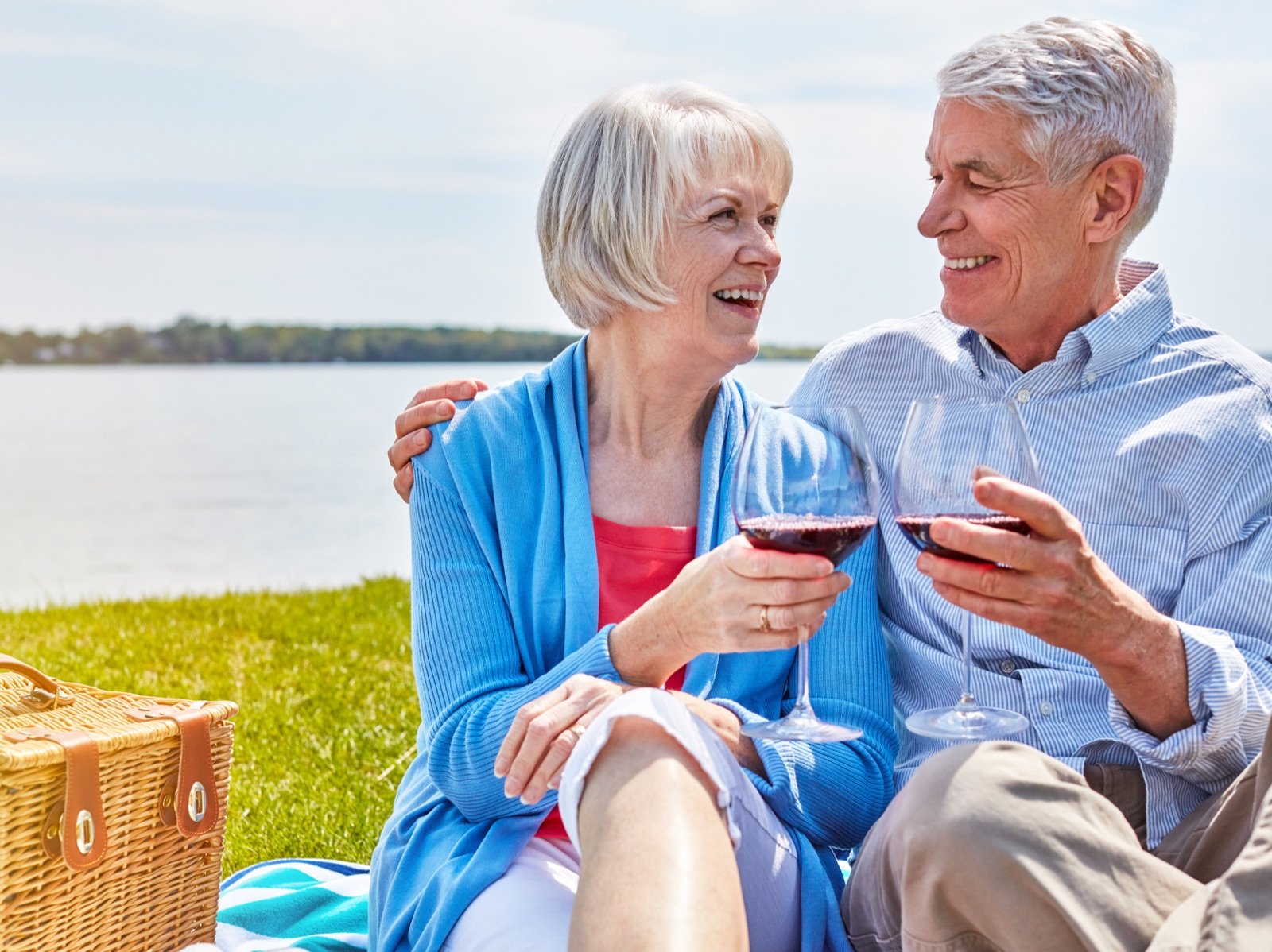 Seniorpar skåler ved søen på en afslappet lokal date