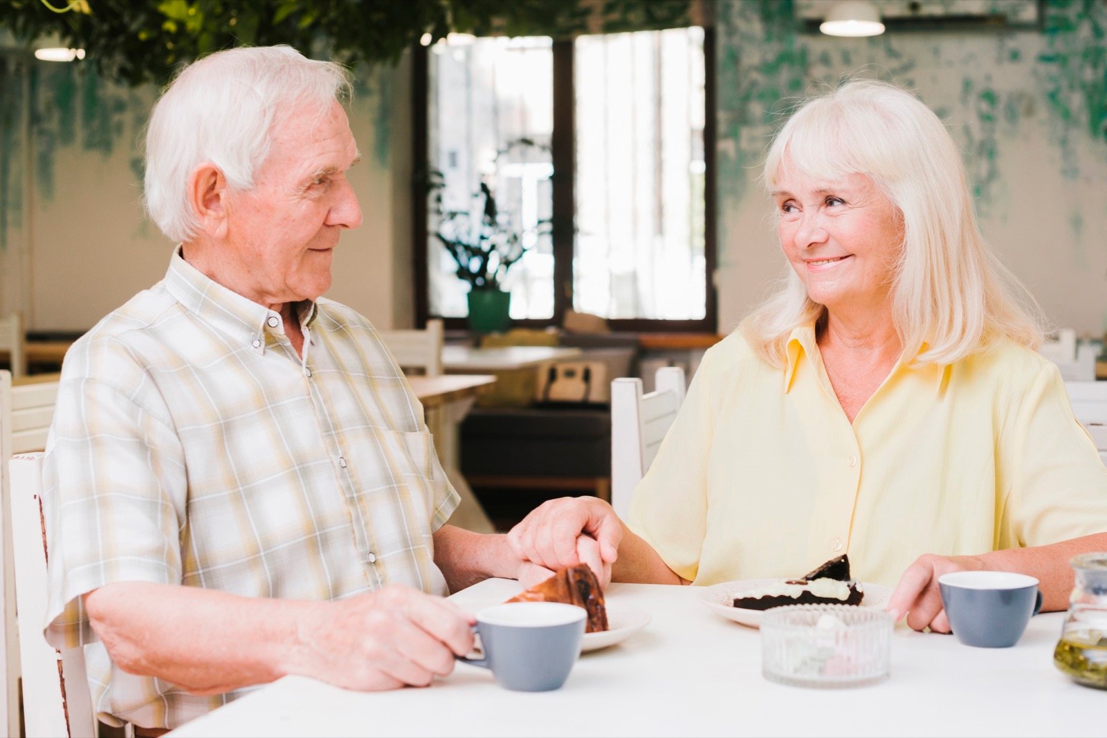 Senior nyder kaffe og dessert som en rolig første aftale